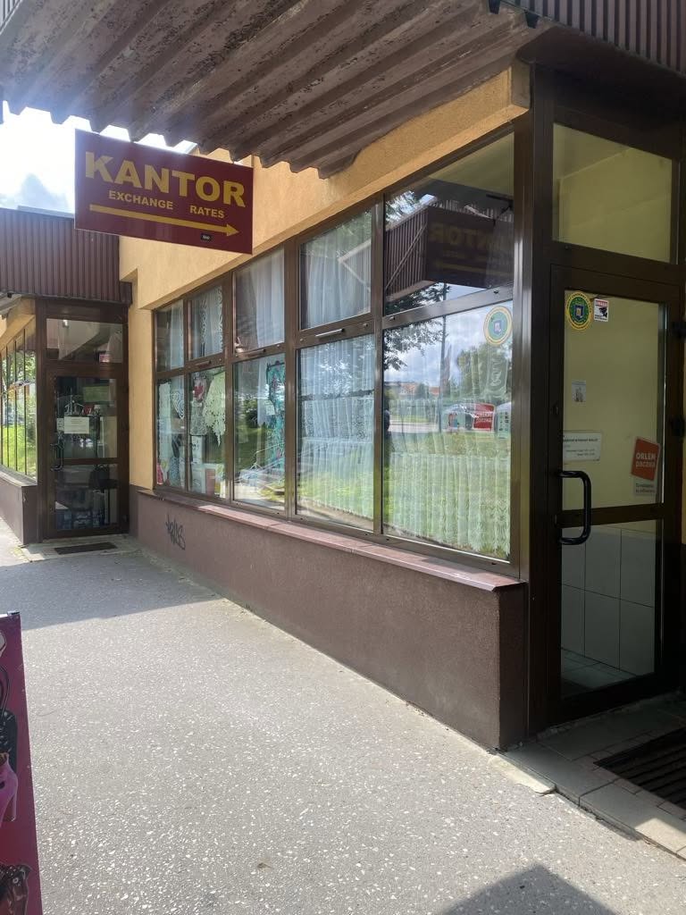 Witryna sklepu przy ul. Armii Krajowej 23 z bordowym szyldem KANTOR, exchange rates nad wejściem